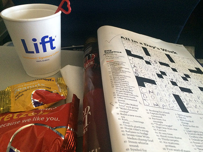 flight necessities: coffee, pretzels and a crossword